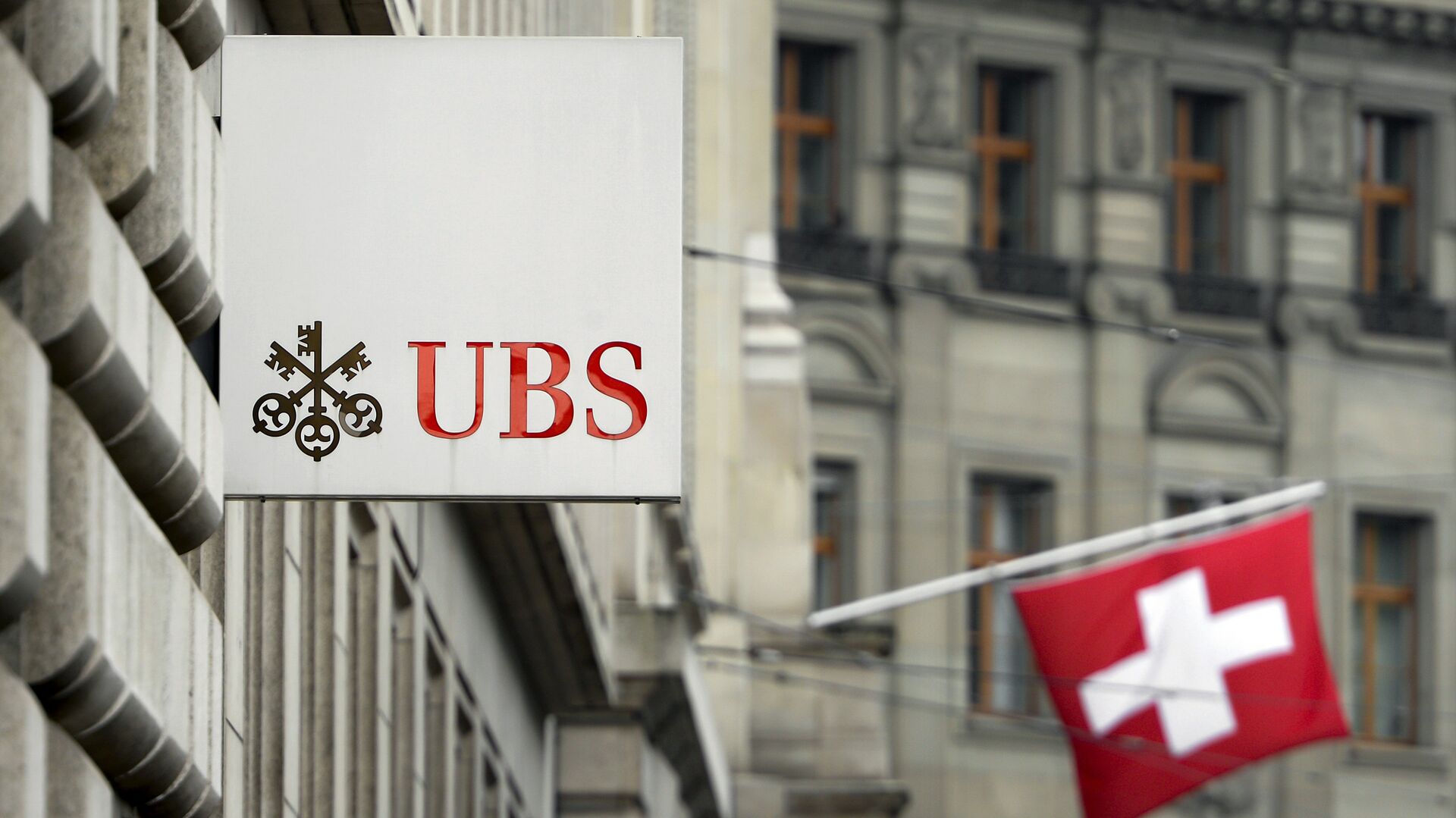 A Swiss flag is seen behind a sign of Swiss bank giant UBS on June 11, 2013 in Basel. - Sputnik International, 1920, 29.03.2023