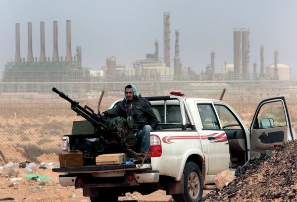 In this March 5, 2011 file photo, an anti-government rebel sits with an anti-aircraft weapon in front an oil refinery, after the capture of the oil town of Ras Lanouf, eastern Libya. In this March 5, 2011 file photo, an anti-government rebel sits with an anti-aircraft weapon in front an oil refinery, after the capture of the oil town of Ras Lanouf, eastern Libya. - Sputnik International
