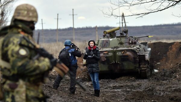 A TV journalist prepares to do a piece to camera in front of an armoured personnel carrier (APC) on the frontline between Ukrainian forces and independent supporters near the eastern Ukrainian city of Debaltseve, in the Donetsk region - Sputnik International