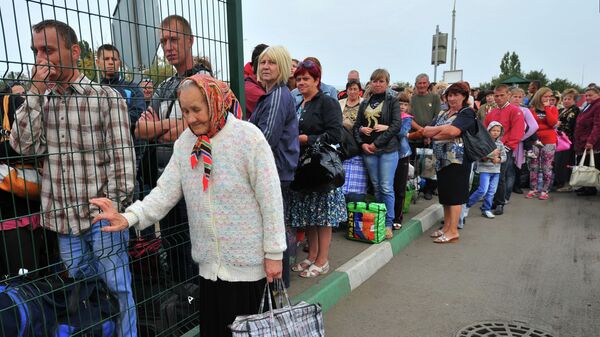 Ukrainian refugees line up to return to their homes in eastern Ukraine at the Russia-Ukraine border check point in the Russian town Donetsk, Rostov-on-Don region, Russia, Friday, Sept. 12, 2014. - Sputnik International