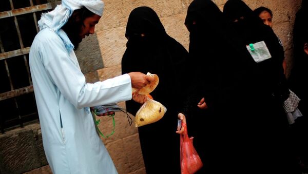 Yemeni women receive free food donated by Yemeni volunteers during the holy month of Ramadan, in Sanaa, Yemen, Friday, June 26, 2015. - Sputnik International