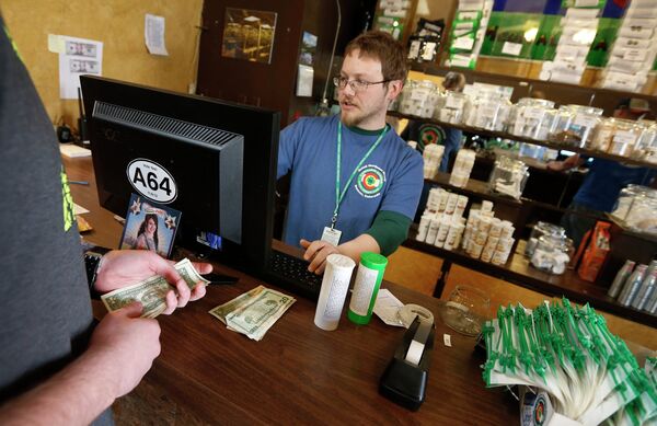 In this May 8, 2014 file photo, a customer pays cash for retail marijuana at 3D Cannabis Center, in Denver. - Sputnik International