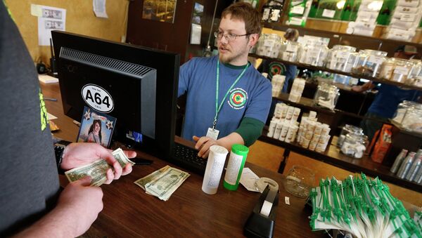 In this May 8, 2014 file photo, a customer pays cash for retail marijuana at 3D Cannabis Center, in Denve - Sputnik International