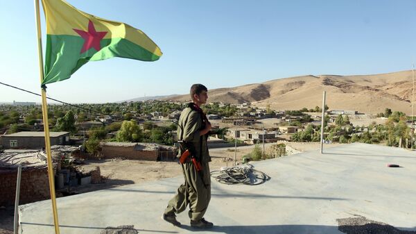 A Kurdistan Workers Party (PKK) fighters guards a post flying the PKK flag. File photo - Sputnik International