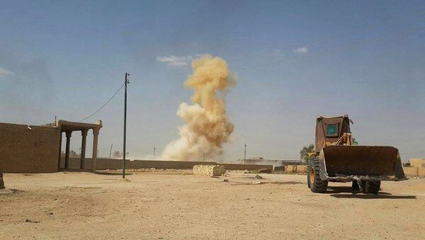In this Sunday, July 19, 2015 photo, smoke rises following a U.S.-led coalition airstrike against Islamic State group positions as a bulldozer belonging to the Iraqi security forces backed by Shiite and pro-government Sunni fighters is deployed for fighting against Islamic State group militants in Tash district in southern Ramadi, Anbar province, Iraq - Sputnik International