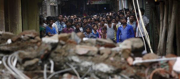 Onlookers stand at the site of a collapsed building - Sputnik International