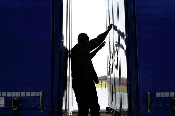 A migrant stands between two trailers of a lorry as he attempts to cross the English Channel, in Calais, northern France, Wednesday, June 24, 2015. A migrant stands between two trailers of a lorry as he attempts to cross the English Channel, in Calais, northern France, Wednesday, June 24, 2015. - Sputnik International