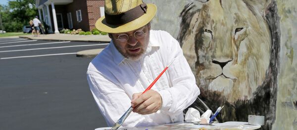 Mark Balma works on a mural of Cecil the lion outside Dr. Walter James Palmer's dental office in Bloomington, Minnesota. - Sputnik International