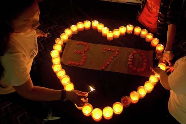 Relatives of Chinese passengers on board the Malaysia Airlines Flight MH370 light candles in a prayer room in Beijing, China, Friday, April 4, 2014. Relatives of Chinese passengers on board the Malaysia Airlines Flight MH370 light candles in a prayer room in Beijing, China, Friday, April 4, 2014. - Sputnik International