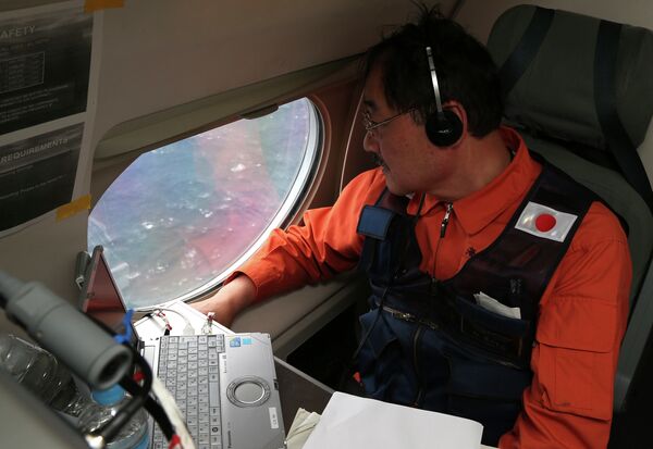 Communications specialist Hidetaka Sato on a Japan Coast Guard Gulfstream aircraft, looks out of a window searching for the missing Malaysia Airlines Flight MH370 in Southern Indian Ocean, near Australia, Tuesday, April 1, 2014. Communications specialist Hidetaka Sato on a Japan Coast Guard Gulfstream aircraft, looks out of a window searching for the missing Malaysia Airlines Flight MH370 in Southern Indian Ocean, near Australia, Tuesday, April 1, 2014. - Sputnik International