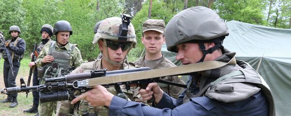 US soldier, left, instructs a Ukrainian soldier during joint training exercises on the military base in the Lviv region. - Sputnik International
