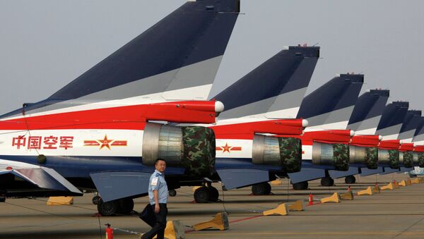 A man walks pasT the Chinese-made J-10 jet fighters on display at the 8th China International Aviation and Aerospace Exhibition (Zhuhai Airshow) in Zhuhai. - Sputnik International