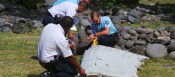 French gendarmes and police inspect a large piece of plane debris which was found on the beach in Saint-Andre. - Sputnik International