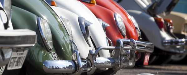 A Volkswagen Beetle toy is seen in front of Beetle cars A Volkswagen Beetle toy is seen in front of Beetle cars - Sputnik International