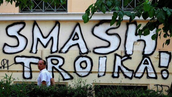 A pedestrian passes graffiti referring to the officials from the European Union, European Central Bank and International Monetary Fund, together known as the troika, in Athens, Wednesday, July 29, 2015. - Sputnik International