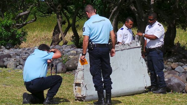 French gendarmes and police inspect a large piece of plane debris which was found on the beach in Saint-Andre - Sputnik International