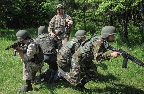 US soldier, center, instructs Ukrainian soldiers during joint training exercises on the military base in the Lviv region, western Ukraine US soldier, center, instructs Ukrainian soldiers during joint training exercises on the military base in the Lviv region, western Ukraine - Sputnik International
