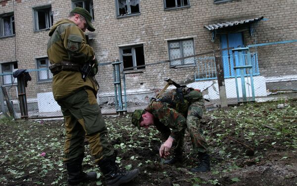 DPR self-defence fighters are measuring a shell carter left by Kiev forces' shelling - Sputnik International