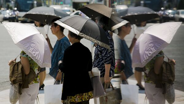 Women hold parasols as they wait at a pedestrian crossing on a hot day in Tokyo - Sputnik International
