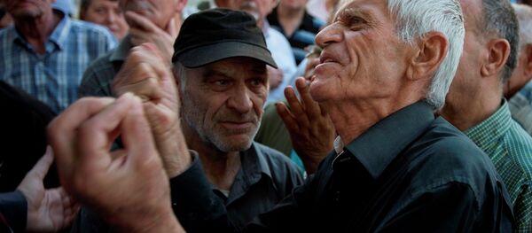 Elderly people argue with a bank worker as they wait to be allowed into the bank to withdraw a maximum of 120 euros ($134) for the week in Athens, Monday, July 6, 2015. Elderly people argue with a bank worker as they wait to be allowed into the bank to withdraw a maximum of 120 euros ($134) for the week in Athens, Monday, July 6, 2015. - Sputnik International