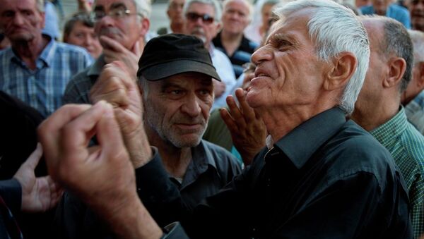Elderly people argue with a bank worker as they wait to be allowed into the bank to withdraw a maximum of 120 euros ($134) for the week in Athens, Monday, July 6, 2015. - Sputnik International