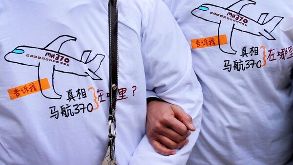 Relatives of passengers on board the Malaysia Airlines Flight 370 that went missing on March 8, 2014, wearing T-shirts carrying a message for the missing flight as they leave Yonghegong Lama Temple after a gathering of family members of the missing passengers, in Beijing Sunday, March 8, 2015. - Sputnik International
