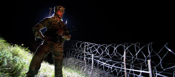 In this Dec. 22, 2013 photo, an Indian army soldier stands guard along barbed wire near the Line of Control (LOC), that divides Kashmir between India and Pakistan, at Krishna Ghati (KG Sector) in Poonch, 290 kilometers (180 miles) from Jammu, India - Sputnik International