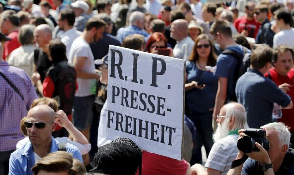 A demonstrator holds up a placard which reads Rest in Peace freedom of press! during a rally to protest against a criminal complaint by the domestic intelligence agency, the Office for the Protection of the Constitution (BfV), over articles about it that appeared on the Netzpolitik.org blog, in Berlin, Germany, August 1, 2015 A demonstrator holds up a placard which reads Rest in Peace freedom of press! during a rally to protest against a criminal complaint by the domestic intelligence agency, the Office for the Protection of the Constitution (BfV), over articles about it that appeared on the Netzpolitik.org blog, in Berlin, Germany, August 1, 2015 - Sputnik International