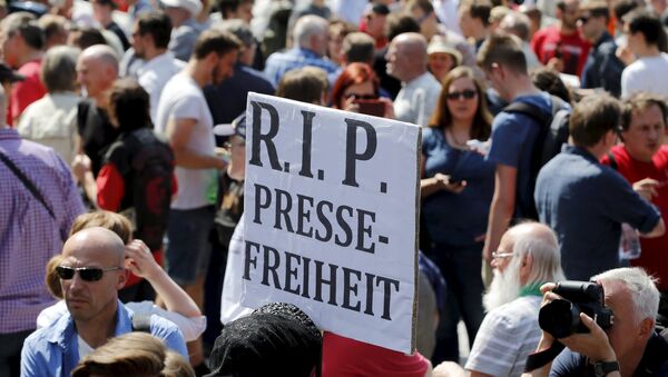 A demonstrator holds up a placard which reads Rest in Peace freedom of press! during a rally to protest against a criminal complaint by the domestic intelligence agency, the Office for the Protection of the Constitution (BfV), over articles about it that appeared on the Netzpolitik.org blog, in Berlin, Germany, August 1, 2015 - Sputnik International
