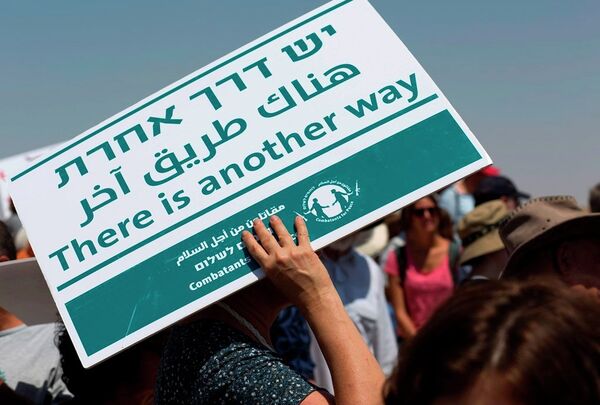A female foreign peace activist covers her head from the sun with a banner during a demonstration, at the village of Susiya, south of the West Bank city of Hebron, Friday, July 24, 2015. A female foreign peace activist covers her head from the sun with a banner during a demonstration, at the village of Susiya, south of the West Bank city of Hebron, Friday, July 24, 2015. - Sputnik International