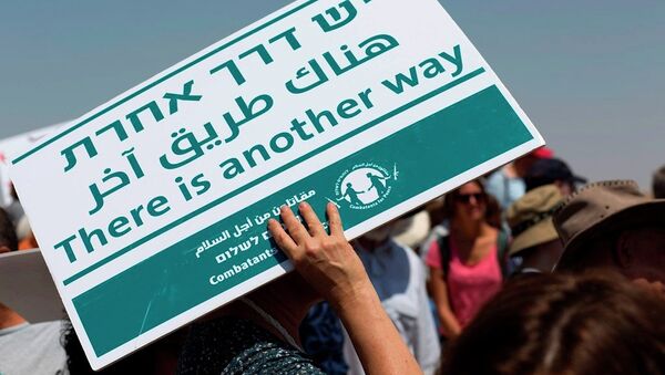 A female foreign peace activist covers her head from the sun with a banner during a demonstration, at the village of Susiya, south of the West Bank city of Hebron, Friday, July 24, 2015. - Sputnik International