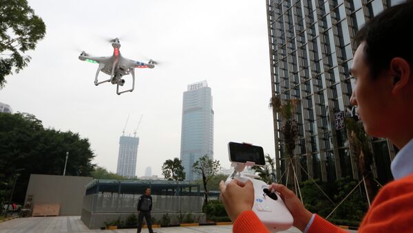 An employee from DJI Technology Co. demonstrates the remote flying with his Phantom 2 Vision+ drone in Shenzhen, south China's Guangdong province. - Sputnik International
