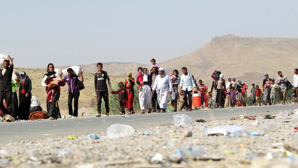 A file picture taken on August 13, 2014, shows displaced Iraqi families from the Yazidi community crossing the Iraqi-Syrian border at the Fishkhabur crossing, in northern Iraq - Sputnik International