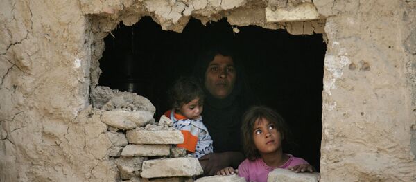 Iraqi family stands inside their home hit by an airstrike in Fidhailiya area in eastern Baghdad, Iraq. - Sputnik International