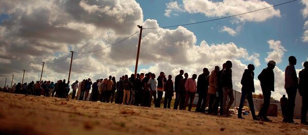 Migrants line up as the wait for a food ration distributed by the Banque Alimentaire of Calais at a camp in northern France, Tuesday, Aug. 4, 2015. Migrants line up as the wait for a food ration distributed by the Banque Alimentaire of Calais at a camp in northern France, Tuesday, Aug. 4, 2015. - Sputnik International