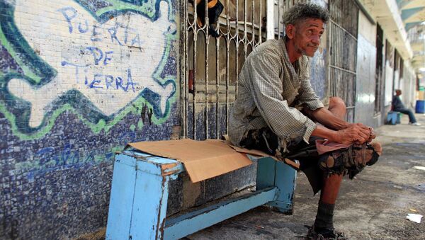 A homeless man improvises his shoes with pieces of cloth in front of a closed down business in Puerta de Tierra in the outskirts of Old San Juan, Puerto Rico, Sunday, Aug. 2, 2015 - Sputnik International