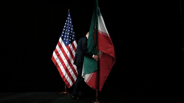 A staff member removes the Iranian flag from the stage after a group picture with foreign ministers and representatives of Unites States, Iran etc. - Sputnik International