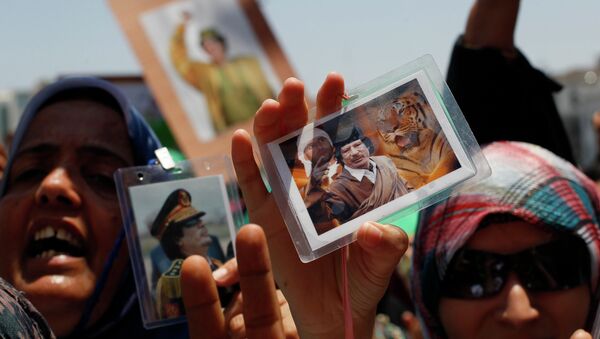 In this file photo taken on a government-organized tour Libyan women show their badges with portraits of Moammar Gadhafi and his son Seif al-Islam as they rally at the Green Square in downtown Tripoli, Libya, on Thursday, June 23, 2011 - Sputnik International