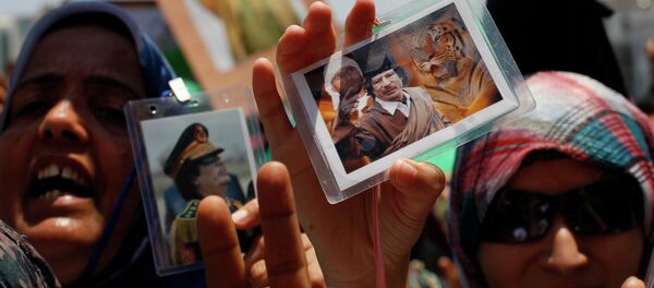 In this file photo taken on a government-organized tour Libyan women show their badges with portraits of Moammar Gadhafi and his son Seif al-Islam as they rally at the Green Square in downtown Tripoli, Libya, on Thursday, June 23, 2011 In this file photo taken on a government-organized tour Libyan women show their badges with portraits of Moammar Gadhafi and his son Seif al-Islam as they rally at the Green Square in downtown Tripoli, Libya, on Thursday, June 23, 2011 - Sputnik International