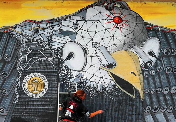 Artist A. Signl, of the artist group Captain Borderline paints the mural 'Surveillance of the fittest' at a wall in Cologne, Germany, Thursday, Oct. 24, 2013. Artist A. Signl, of the artist group Captain Borderline paints the mural 'Surveillance of the fittest' at a wall in Cologne, Germany, Thursday, Oct. 24, 2013. - Sputnik International