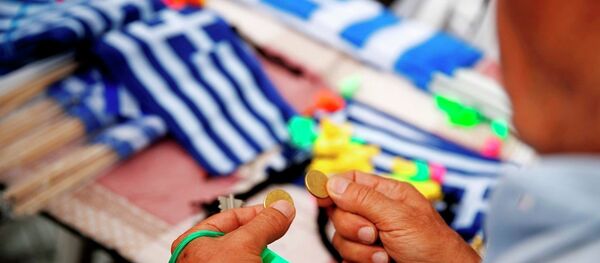 A man holds coins as he prepares to buy Greek flags during a rally organized by supporters of the YES vote to referendum in Athens, June 30, 2015. - Sputnik International