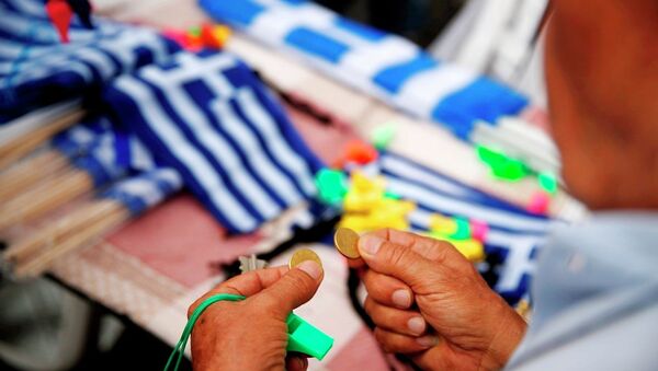 A man holds coins as he prepares to buy Greek flags during a rally organized by supporters of the YES vote to referendum in Athens, June 30, 2015. - Sputnik International