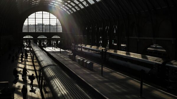 Passengers walk down a platform at King's Cross railway station, London - Sputnik International
