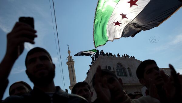 Men hold revolutionary Syrian flags during an anti-government protest in a town in northern Syria - Sputnik International