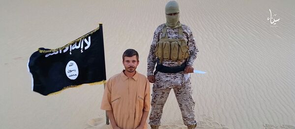 This image made from a militant video posted on a social media website on Wednesday, Aug. 5, 2015, which has been verified and is consistent with other AP reporting, purports to show a militant standing next to another man who identifies himself as 30-year-old Tomislav Salopek, kneeling down as he reads a message at an unknown location This image made from a militant video posted on a social media website on Wednesday, Aug. 5, 2015, which has been verified and is consistent with other AP reporting, purports to show a militant standing next to another man who identifies himself as 30-year-old Tomislav Salopek, kneeling down as he reads a message at an unknown location - Sputnik International