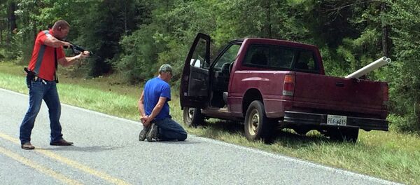 A Mississippi Bureau of Investigation agent detains a person of interest after shots were reportedly fired a second consecutive day Wednesday near Camp Shelby, Mississippi. - Sputnik International