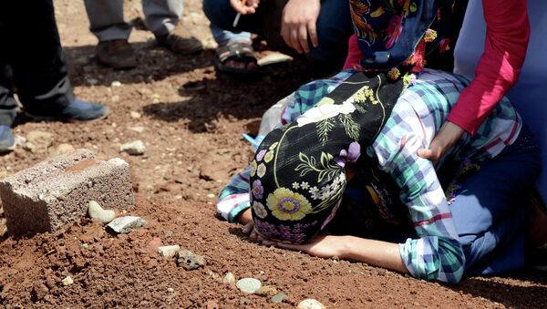 A woman mourns over the grave of a fighter of the Kurdish People's Protection Units (YPG) following a funeral in Diyarbakir in southeastern Turkey - Sputnik International