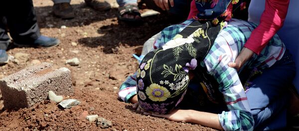 A woman mourns over the grave of a fighter of the Kurdish People's Protection Units (YPG) following a funeral in Diyarbakir in southeastern Turkey A woman mourns over the grave of a fighter of the Kurdish People's Protection Units (YPG) following a funeral in Diyarbakir in southeastern Turkey - Sputnik International