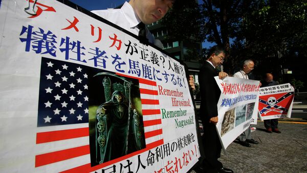 Member of a rightist group offer silent prayers for the victims of the atomic bombing with anti-US banners near the US Embassy in Tokyo, Thursday, Aug. 6, 2015. - Sputnik International