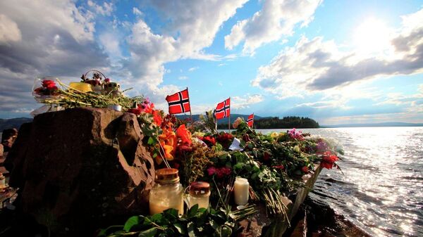 Norwegian flags and flowers are seen in Sundvollen, close to Utoya island, background, where gunman Anders Behring Breivik killed at least 68 people, near Oslo, Norway (Foto vom 28.07.11). - Sputnik International